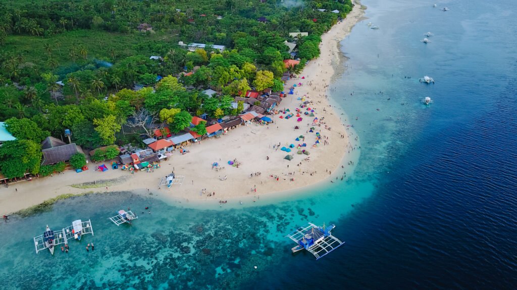Aerial view of sandy beach with tourists swimming in beautiful c
